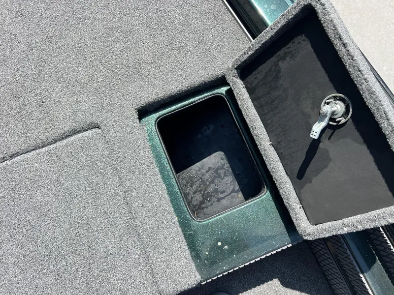 Slide: The Image of 1994 Skeeter 140 SLS boat storage compartment with open lid and carpeted interior. - 10