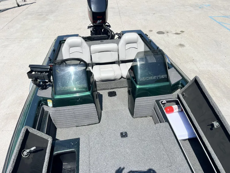 Slide: The Image of 1994 Skeeter 140 SLS boat interior with seating, storage compartments, and motor. - 11