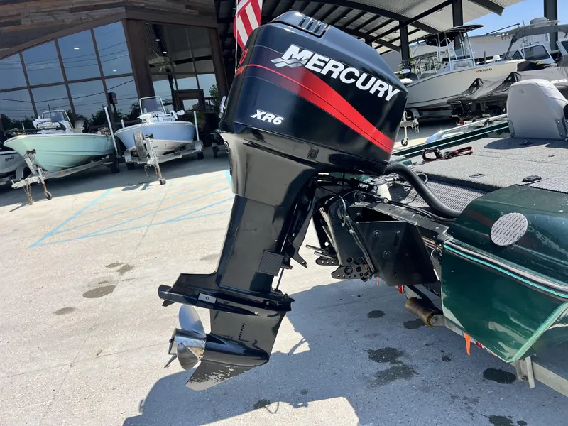 Slide: The Image of 1994 Skeeter 140 SLS with Mercury XR6 outboard motor in a boatyard. - 18