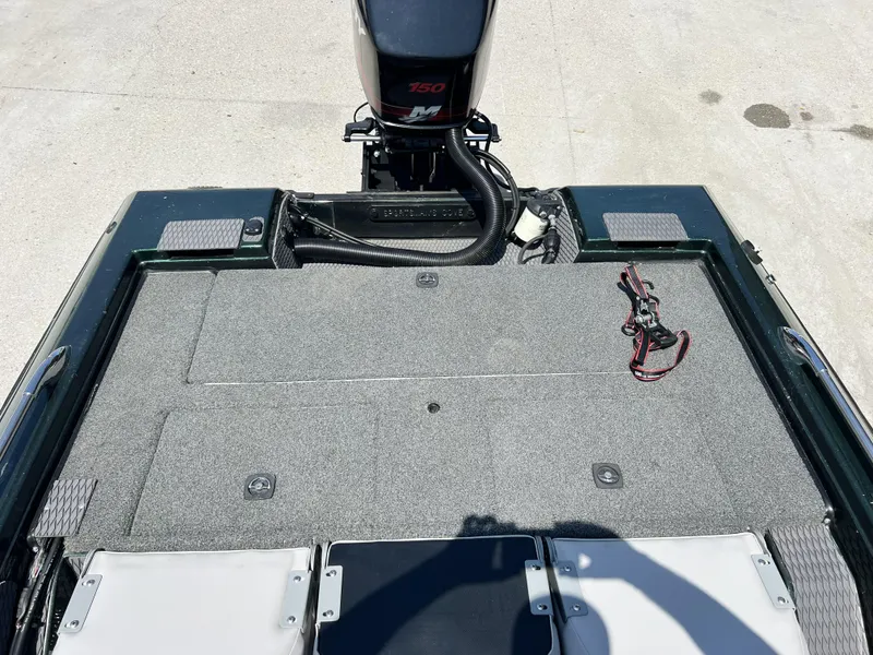 Slide: The Image of 1994 Skeeter 140 SLS boat deck with motor and carpeted surface. - 25