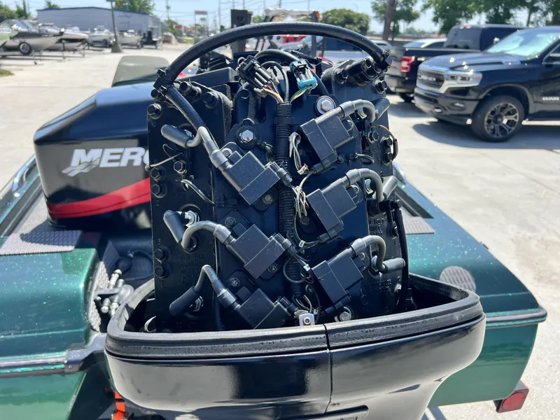 Slide: The Image of 1994 Skeeter 140 SLS boat engine with visible wiring and components in a parking lot. - 6