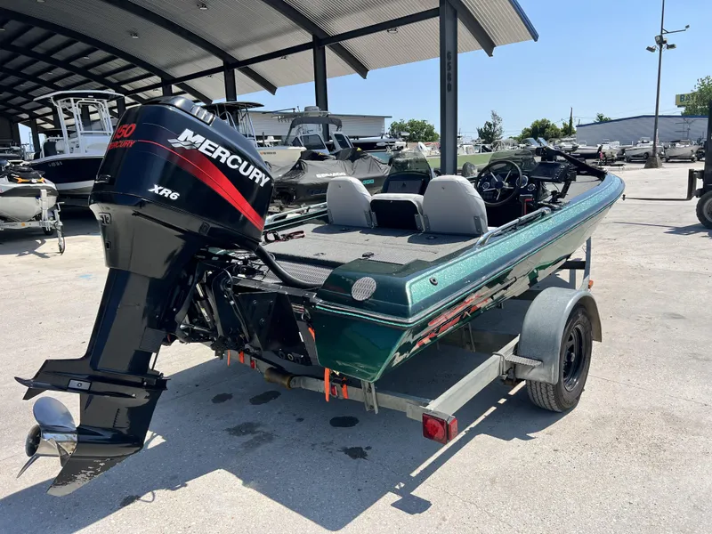 Slide: The Image of 1994 Skeeter 140 SLS boat with Mercury XR6 engine on a trailer in a marina. - 7