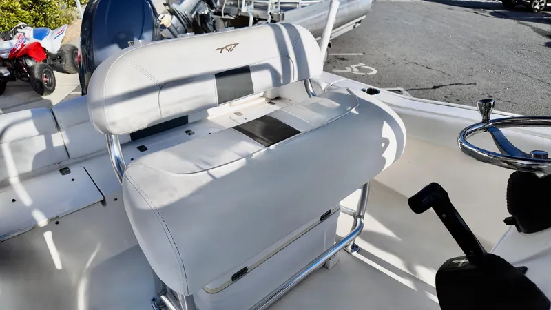 Slide: The Image of 2014 Tidewater 210 LXF boat interior with white seating and steering wheel. - 10