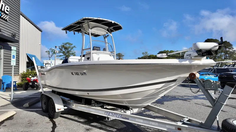 Slide: The Image of 2014 Tidewater 210 LXF boat on trailer, parked outdoors under clear blue sky. - 3