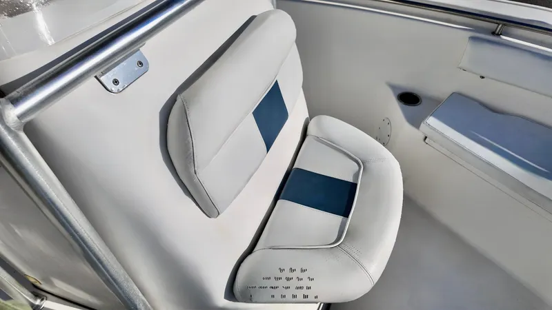 Slide: The Image of 2014 Tidewater 210 LXF boat seat with white and blue cushioned design. - 8