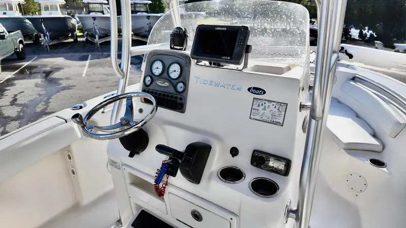 Slide: The Image of 2014 Tidewater 210 LXF boat dashboard with steering wheel and navigation instruments. - 9