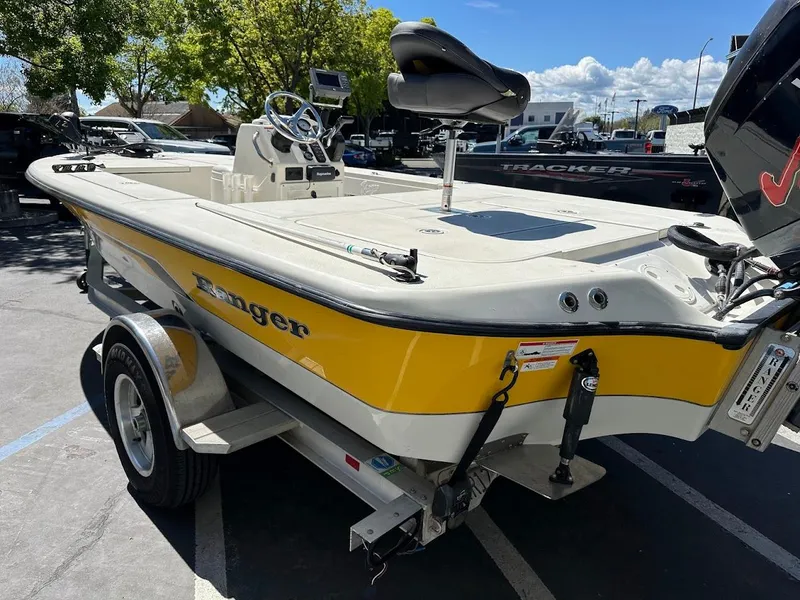 Slide: The Image of 2007 Ranger 191 Cayman boat on trailer, yellow and white, parked outdoors. - 12