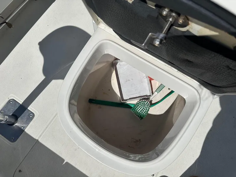 Slide: The Image of Open storage compartment on 2007 Ranger 191 Cayman boat with cleaning tools inside. - 24
