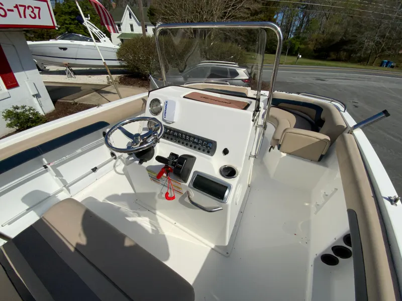 Slide: The Image of 2016 Hurricane Center Console 19 OB boat with steering wheel and seating, docked outdoors. - 11