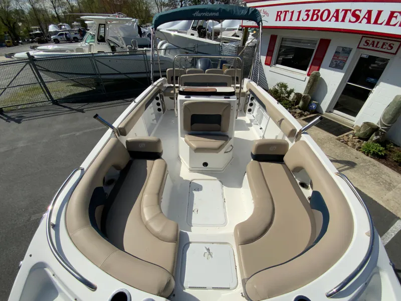 Slide: The Image of 2016 Hurricane Center Console 19 OB boat with beige seating, displayed at a sales lot. - 14