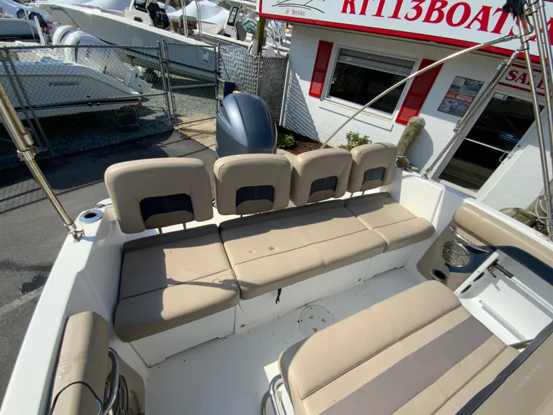 Slide: The Image of 2016 Hurricane Center Console 19 OB boat with beige seating, displayed at a dealership. - 17