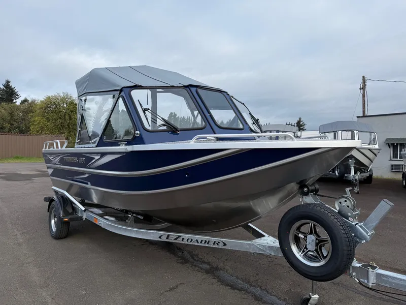 Slide: The Image of 2025 Thunder Jet 185 Luxor boat on trailer, blue and silver design, parked outdoors. - 0