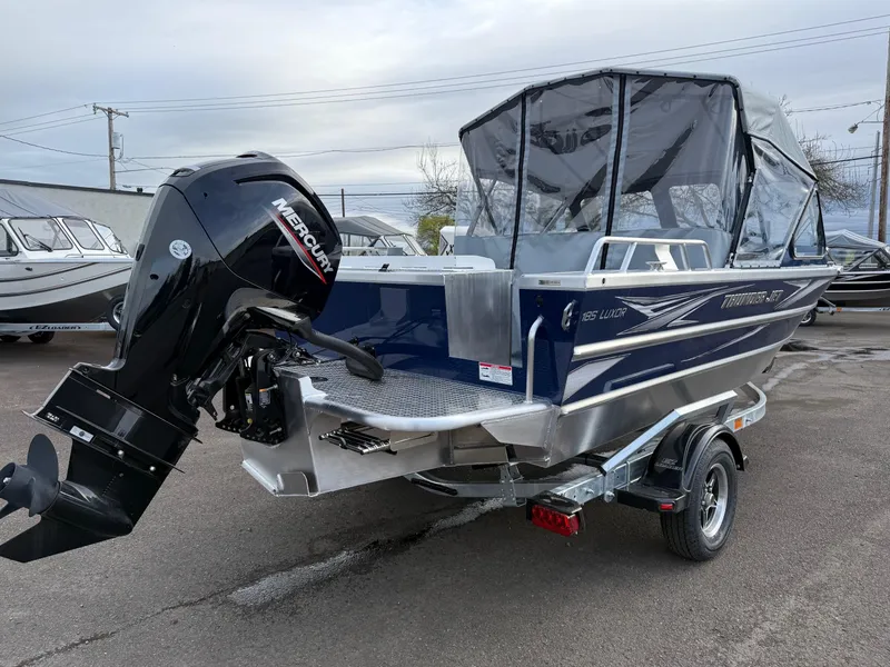Slide: The Image of 2025 Thunder Jet 185 Luxor boat with Mercury outboard motor, parked on a trailer. - 2