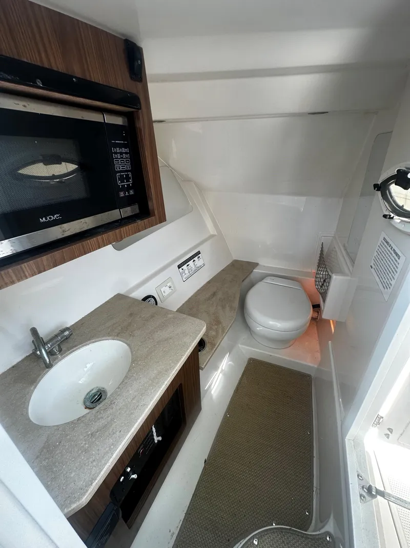 Slide: The Image of 2018 Sailfish 325DC boat interior with sink, microwave, and toilet. - 11
