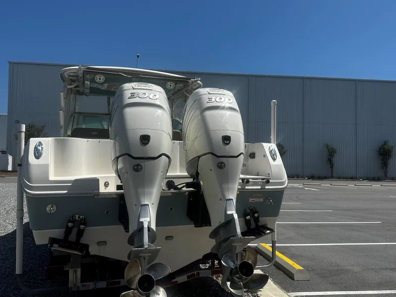 Slide: The Image of 2018 Sailfish 325DC boat with dual 300 horsepower outboard engines in a parking lot. - 2