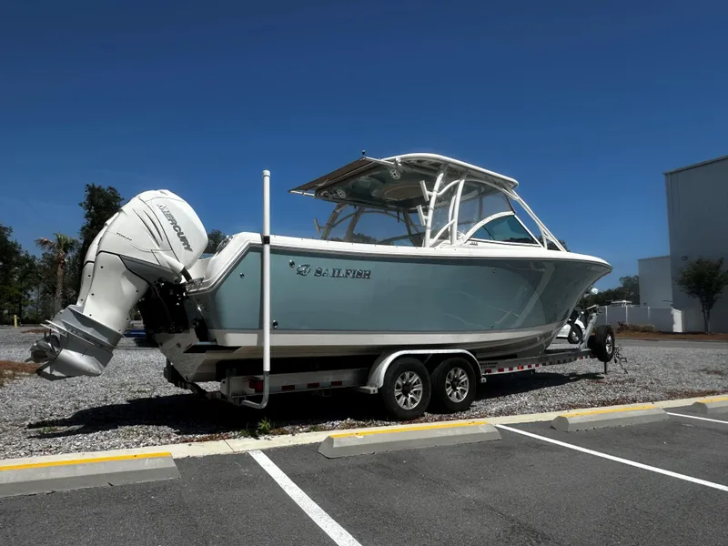 Slide: The Image of 2018 Sailfish 325DC boat on trailer, parked in a lot under clear blue sky. - 5