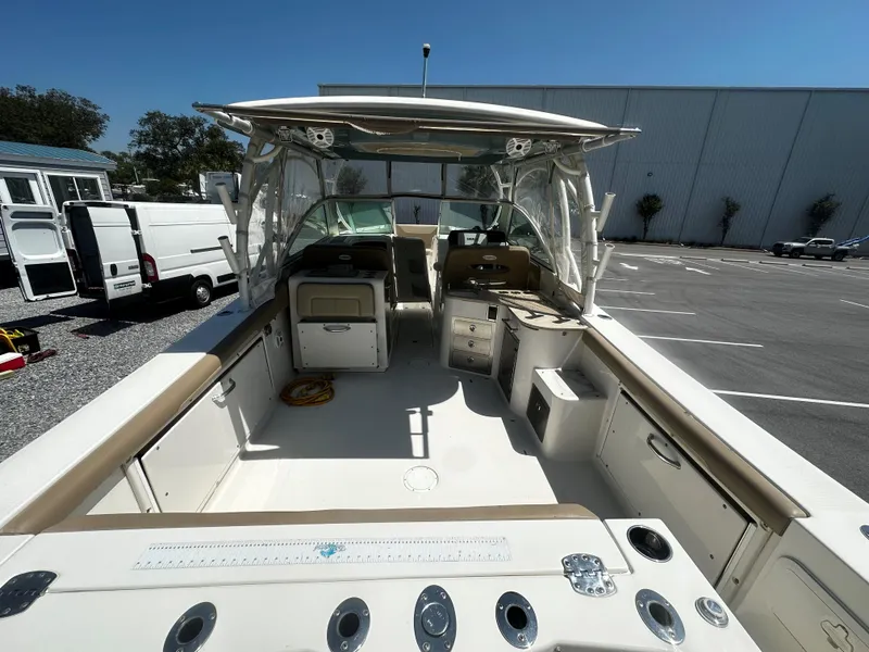 Slide: The Image of 2018 Sailfish 325DC boat interior, featuring spacious deck and seating under clear blue sky. - 6