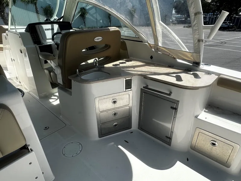 Slide: The Image of 2018 Sailfish 325DC boat interior with helm, sink, and storage compartments. - 7