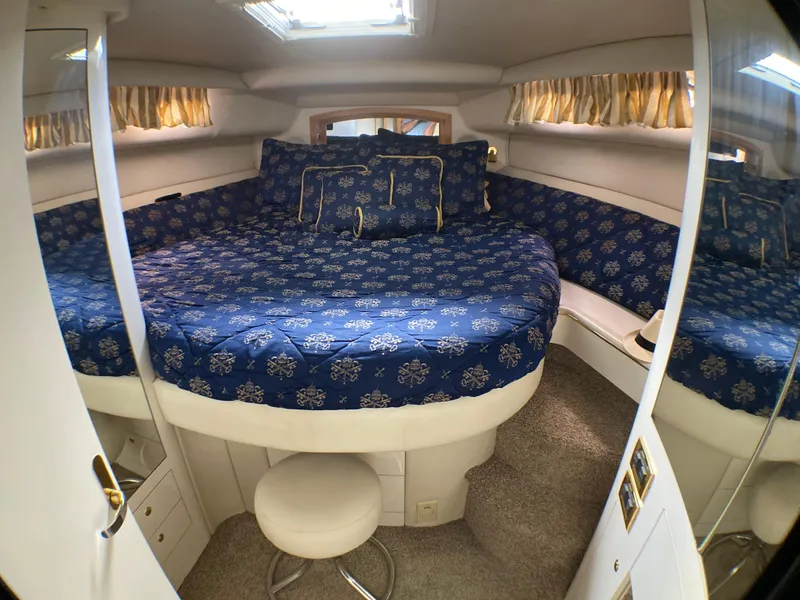 Slide: The Image of Interior cabin of a 1997 Sea Ray 450 Sundancer with blue patterned bedding. - 12