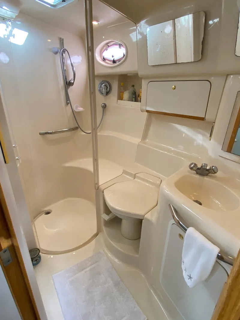 Slide: The Image of 1997 Sea Ray 450 Sundancer bathroom with shower, sink, and storage cabinets. - 15