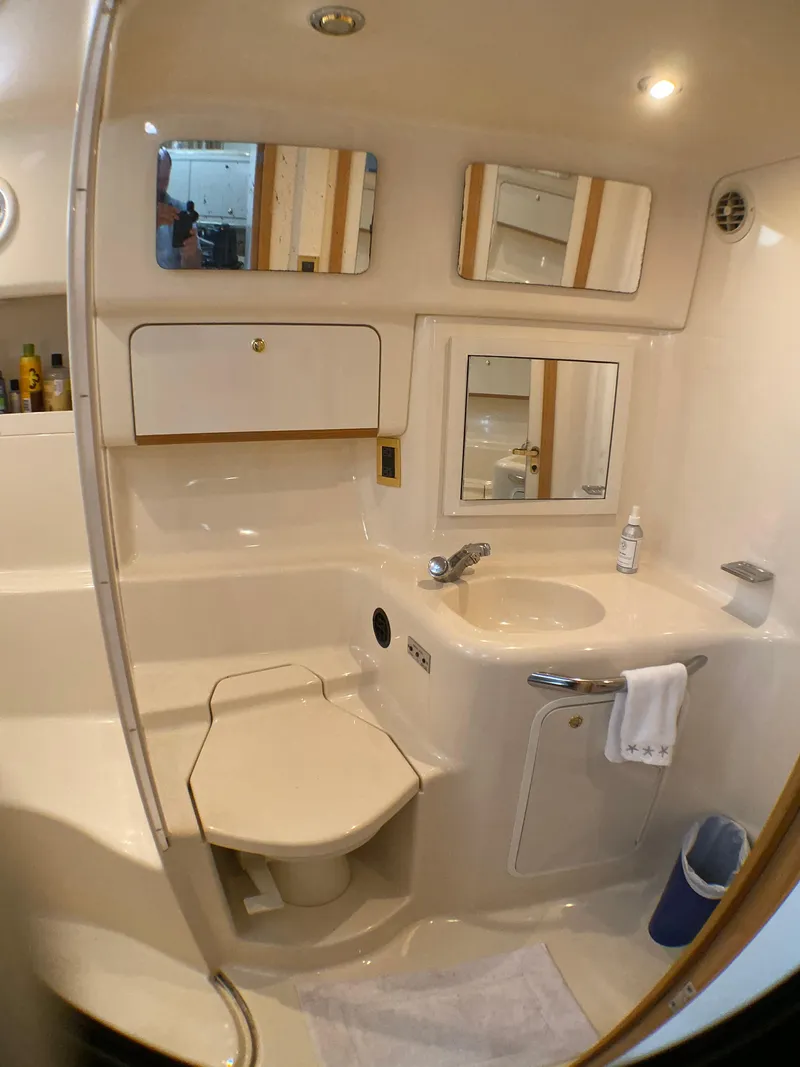 Slide: The Image of Bathroom interior of 1997 Sea Ray 450 Sundancer yacht, featuring sink, toilet, and mirrors. - 16