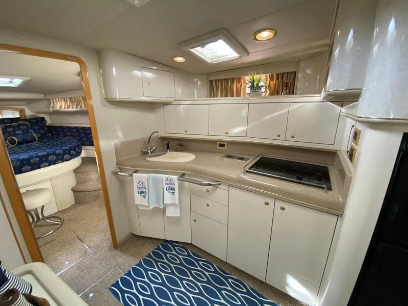 Slide: The Image of 1997 Sea Ray 450 Sundancer yacht interior with modern kitchen and cozy sleeping area. - 17