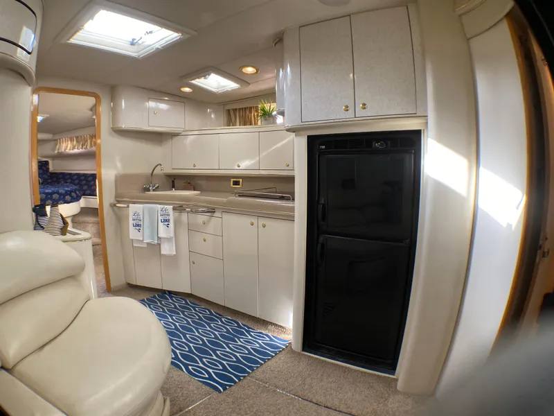 Slide: The Image of Interior of 1997 Sea Ray 450 Sundancer yacht, featuring a modern kitchen area. - 18