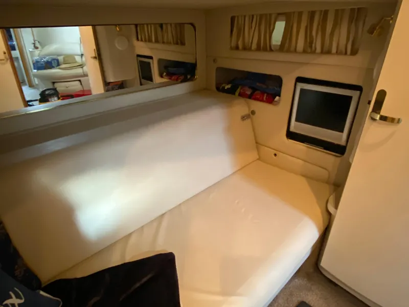 Slide: The Image of Interior of 1997 Sea Ray 450 Sundancer with white seating and small TV. - 23