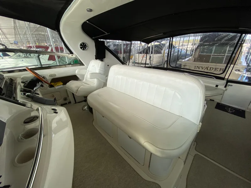 Slide: The Image of Interior of 1997 Sea Ray 450 Sundancer yacht with white seating and helm. - 8