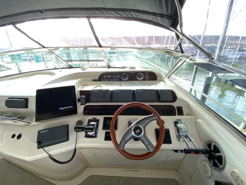 Slide: The Image of 1997 Sea Ray 450 Sundancer helm with steering wheel, controls, and navigation equipment. - 9