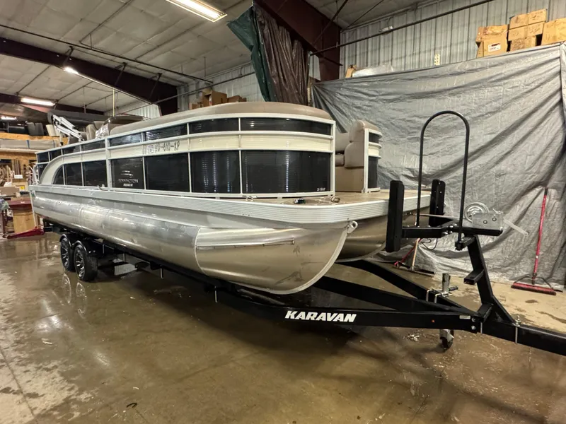 Slide: The Image of 2018 Bennington 25 SSXAPG pontoon boat on Karavan trailer in warehouse. - 0