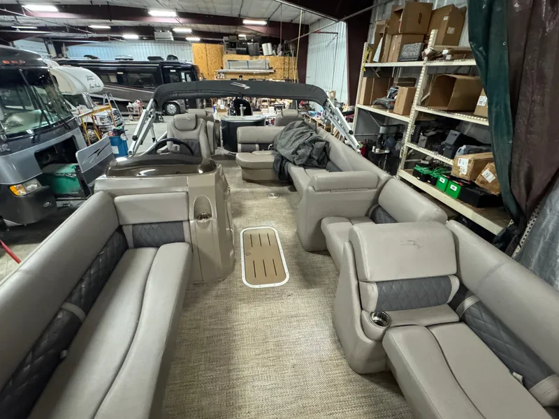 Slide: The Image of 2018 Bennington 25 SSXAPG pontoon boat interior with spacious seating in a storage facility. - 19