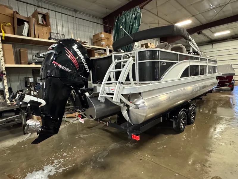 Slide: The Image of 2018 Bennington 25 SSXAPG pontoon boat in a garage with Mercury outboard motor. - 3