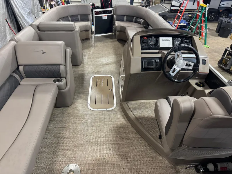 Slide: The Image of 2018 Bennington 25 SSXAPG pontoon boat interior with beige seating and steering console. - 9