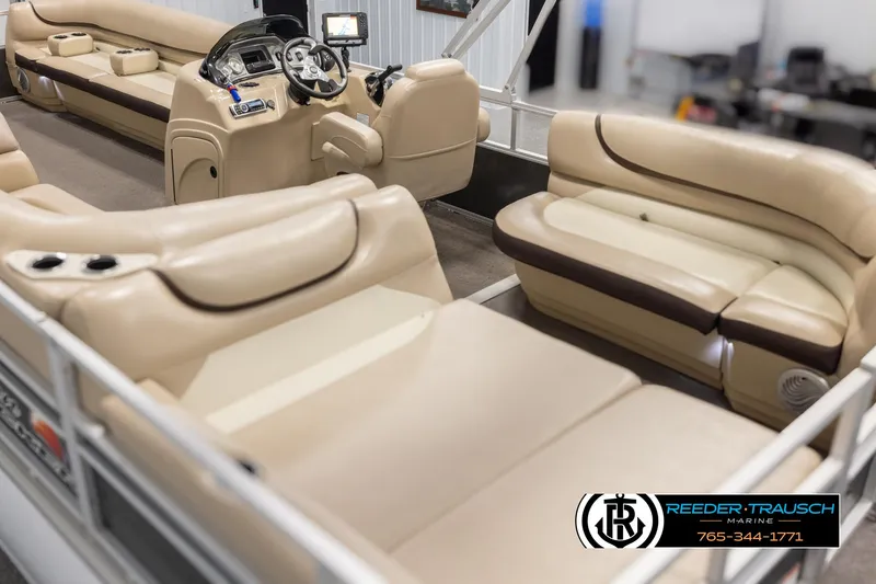 Slide: The Image of 2016 Sun Tracker 24 Party Barge interior with beige seating and steering console. - 11