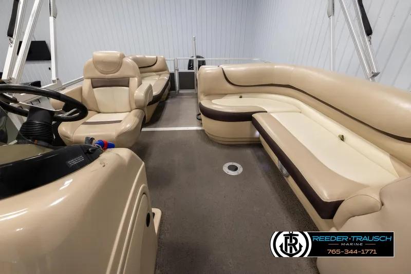 Slide: The Image of 2016 Sun Tracker 24 Party Barge interior with beige seating and steering console. - 14