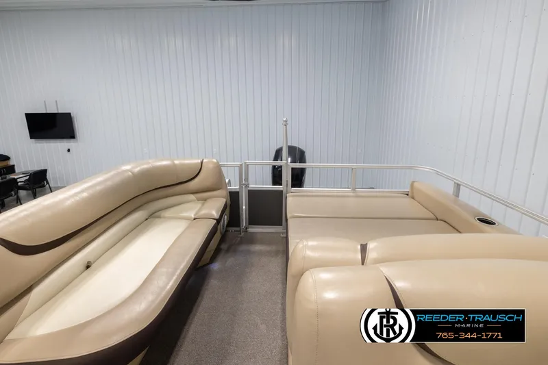 Slide: The Image of 2016 Sun Tracker 24 Party Barge interior with beige seating in a showroom. - 16
