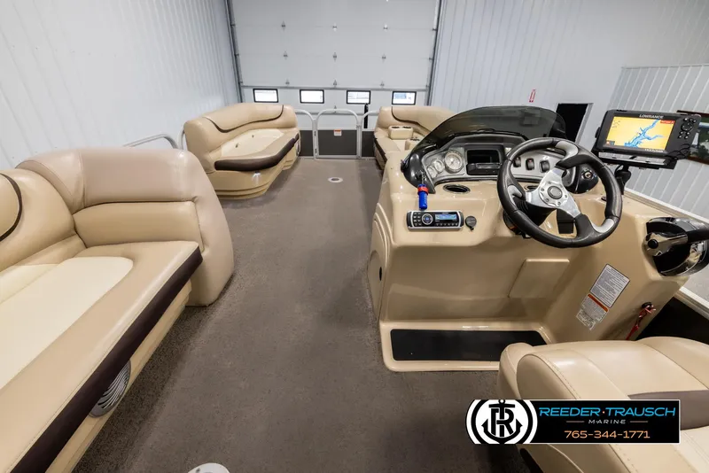 Slide: The Image of 2016 Sun Tracker 24 Party Barge interior with beige seating and modern dashboard. - 19