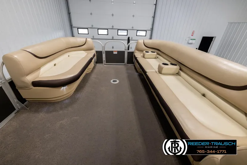 Slide: The Image of 2016 Sun Tracker 24 Party Barge interior with beige seating in a garage. - 20