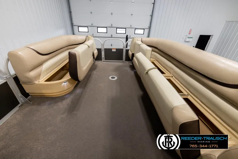 Slide: The Image of 2016 Sun Tracker 24 Party Barge interior with beige seating in a garage setting. - 21