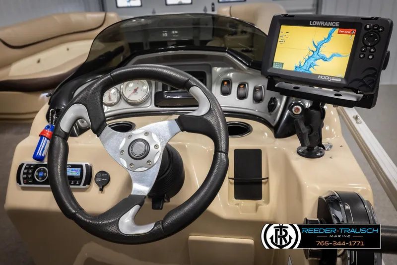 Slide: The Image of 2016 Sun Tracker 24 Party Barge dashboard with steering wheel and navigation system. - 24