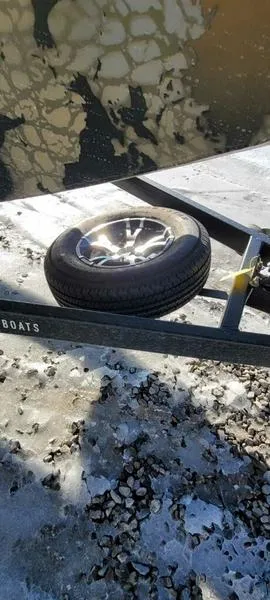 Slide: The Image of 2023 Thor Lake Hammer 1754 Deluxe trailer with spare tire on rocky ground. - 5