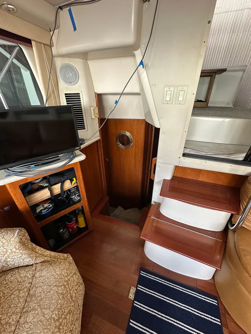 Slide: The Image of Interior of 2003 Carver 356 Motor Yacht with stairs, TV, and storage shelves. - 17