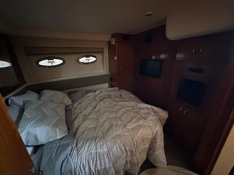 Slide: The Image of Cozy bedroom interior of 2003 Carver 356 Motor Yacht with porthole windows and wood cabinetry. - 18