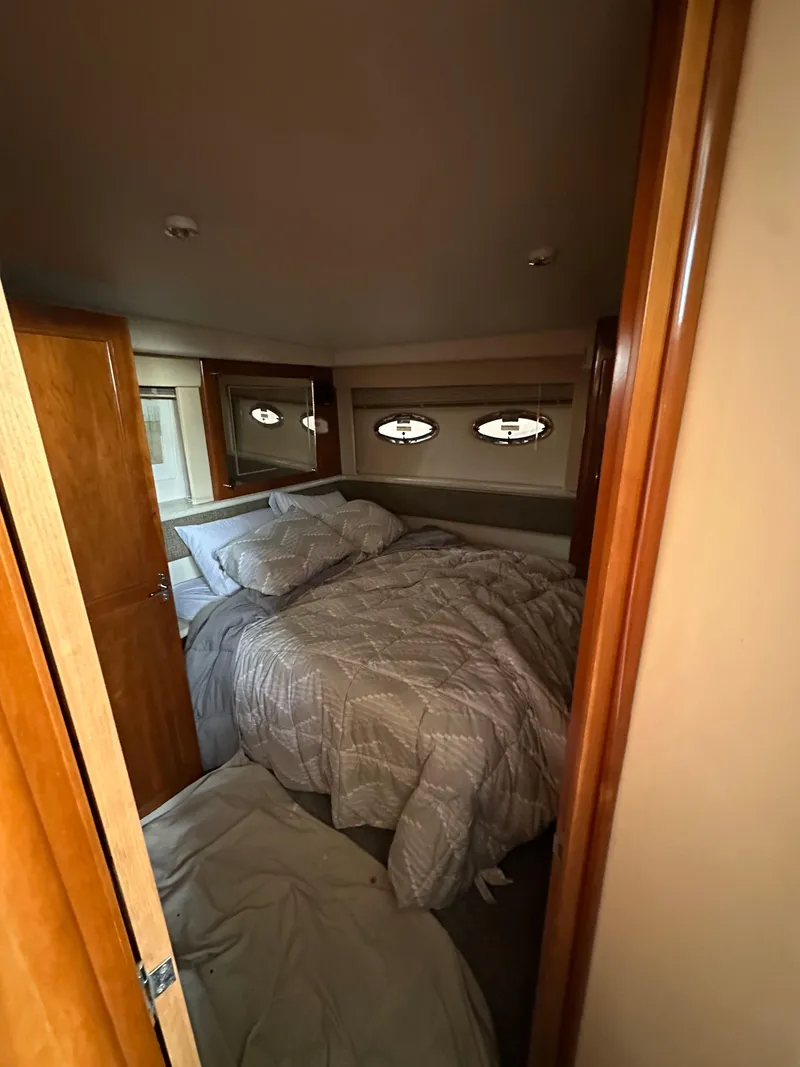 Slide: The Image of 2003 Carver 356 Motor Yacht bedroom with cozy bedding and porthole windows. - 20