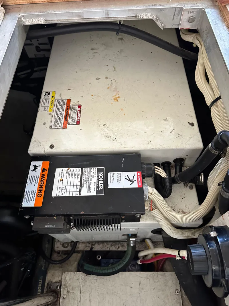 Slide: The Image of Engine compartment of a 2003 Carver 356 Motor Yacht, featuring mechanical components and wiring. - 23