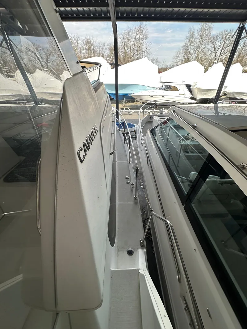 Slide: The Image of 2003 Carver 356 Motor Yacht docked alongside another boat under a covered marina. - 33