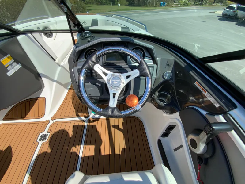 Slide: The Image of 2017 Monterey 217 Outboard boat cockpit with steering wheel and wood-patterned flooring. - 15