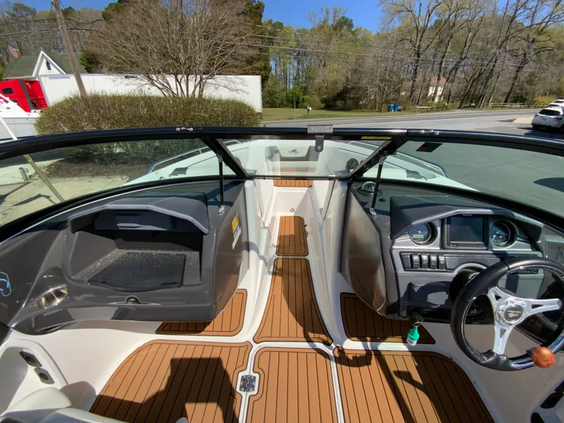 Slide: The Image of 2017 Monterey 217 Outboard boat interior with wood flooring and steering console. - 17
