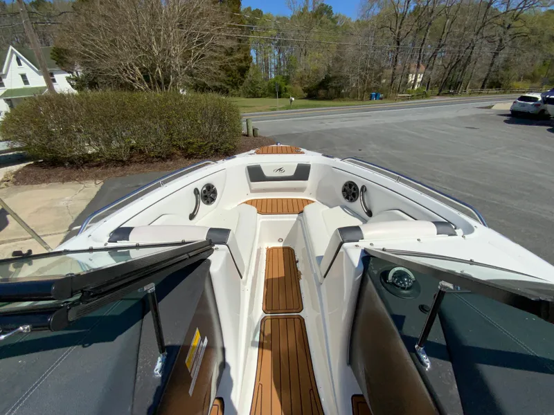 Slide: The Image of 2017 Monterey 217 Outboard boat with teak flooring and spacious seating in a driveway setting. - 18